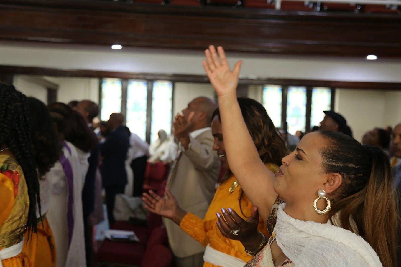 A woman worshiping with her hand raised