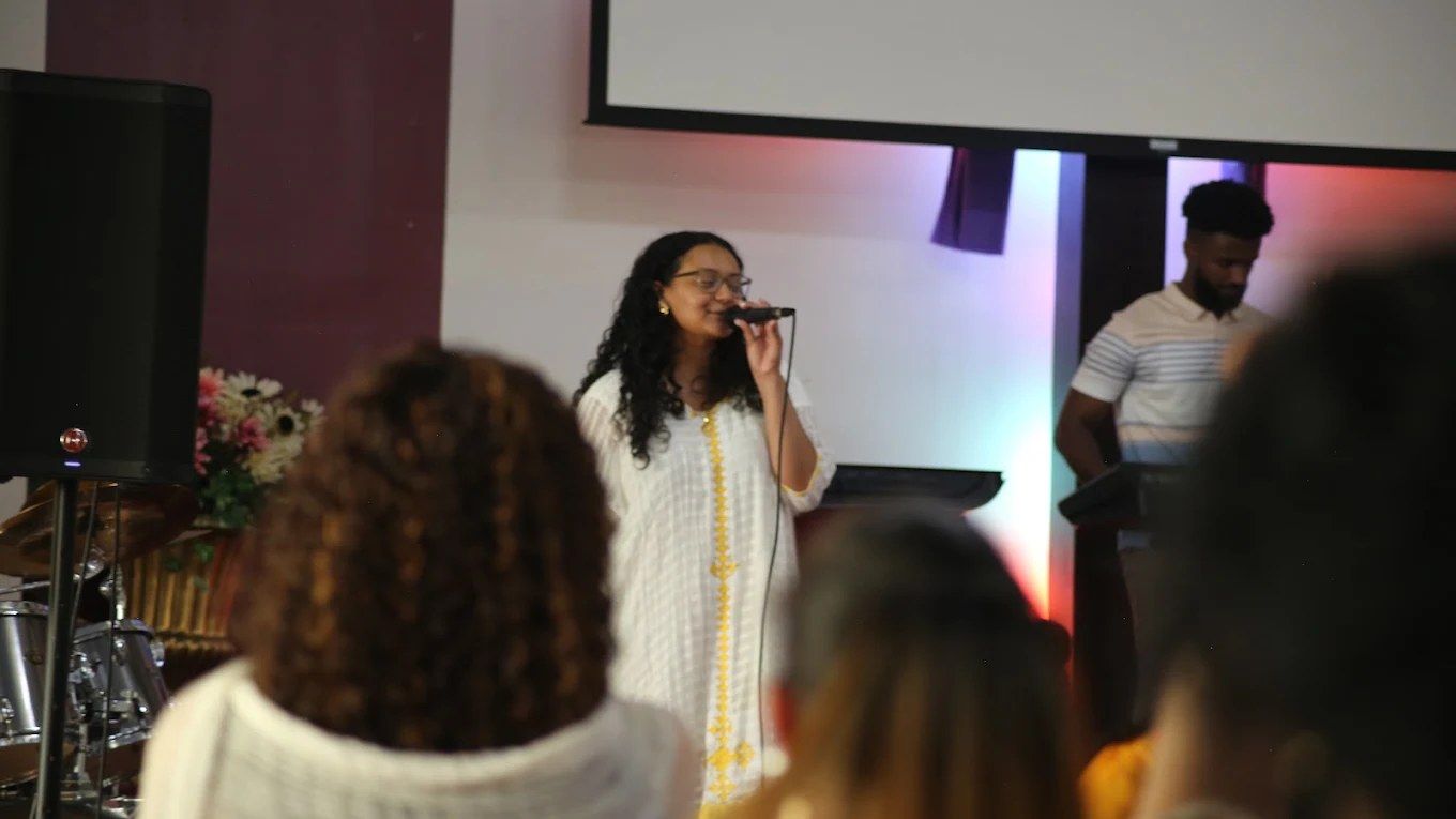A worship leader singing on stage